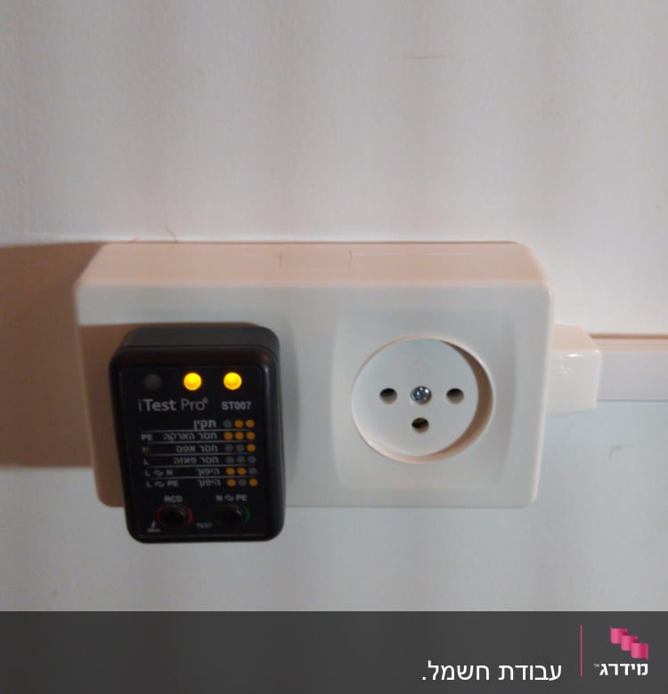 בודק שקע חשמלי עם מכשיר בדיקה